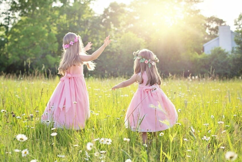 zwei Mädchen tanzen im Gras